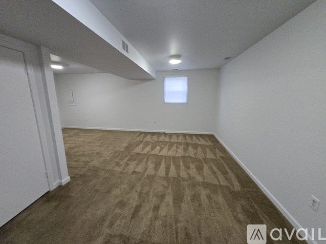 A room with a carpeted floor and a window.