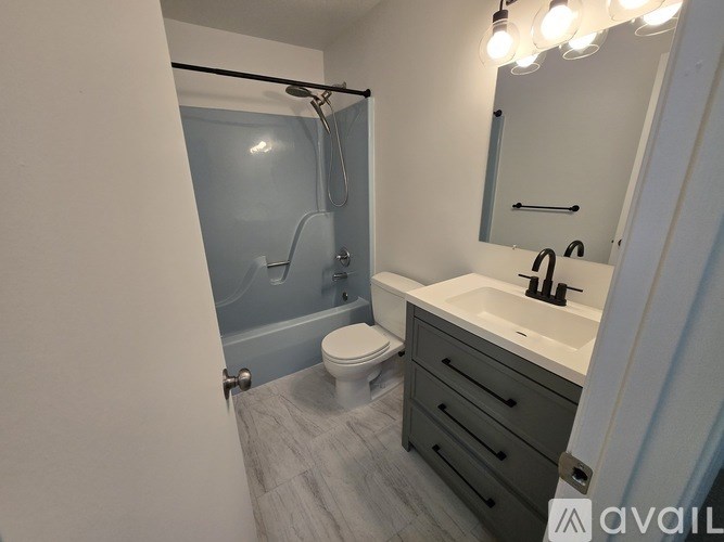 A bathroom with a toilet, sink, and shower.