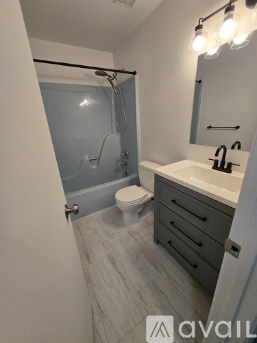 A bathroom with a toilet, sink, and shower.