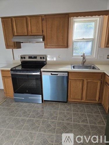 A kitchen with a stove, sink, and dishwasher.