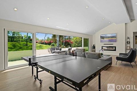 A spacious living room with a large table and a television.