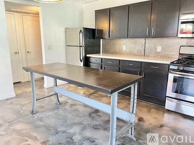 A kitchen with a table and a fridge.