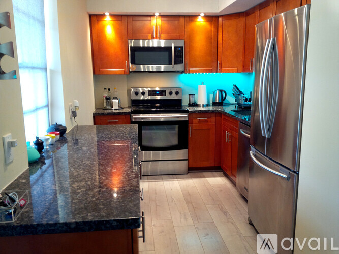 A kitchen with a black granite countertop and stainless steel appliances.