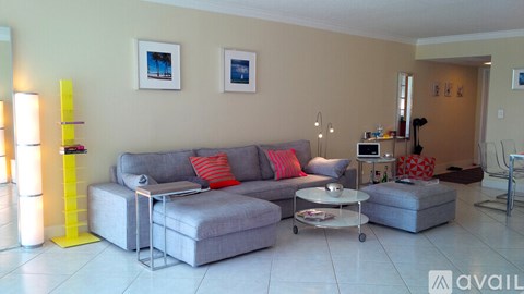 A living room with a grey couch and a white coffee table.