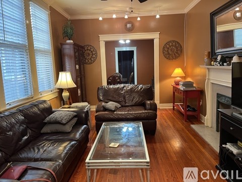 A living room with brown leather couches and a glass coffee table.