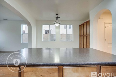 A kitchen with a granite countertop and wooden cabinets is available for sale.