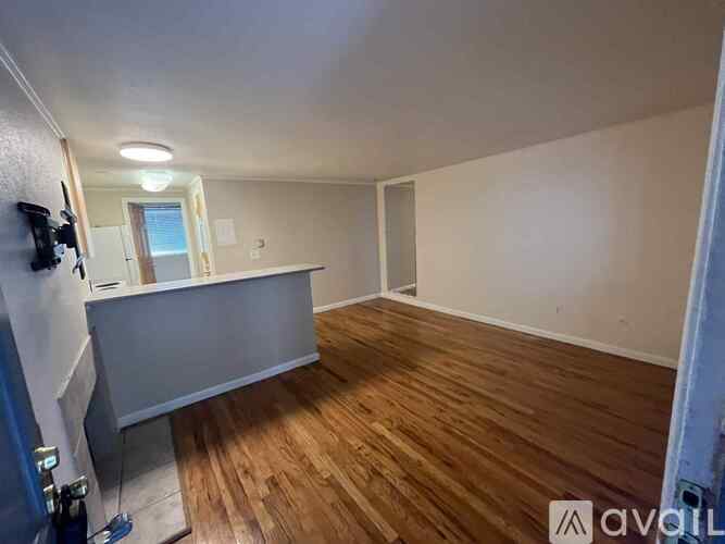 A room with wooden flooring and a white wall.