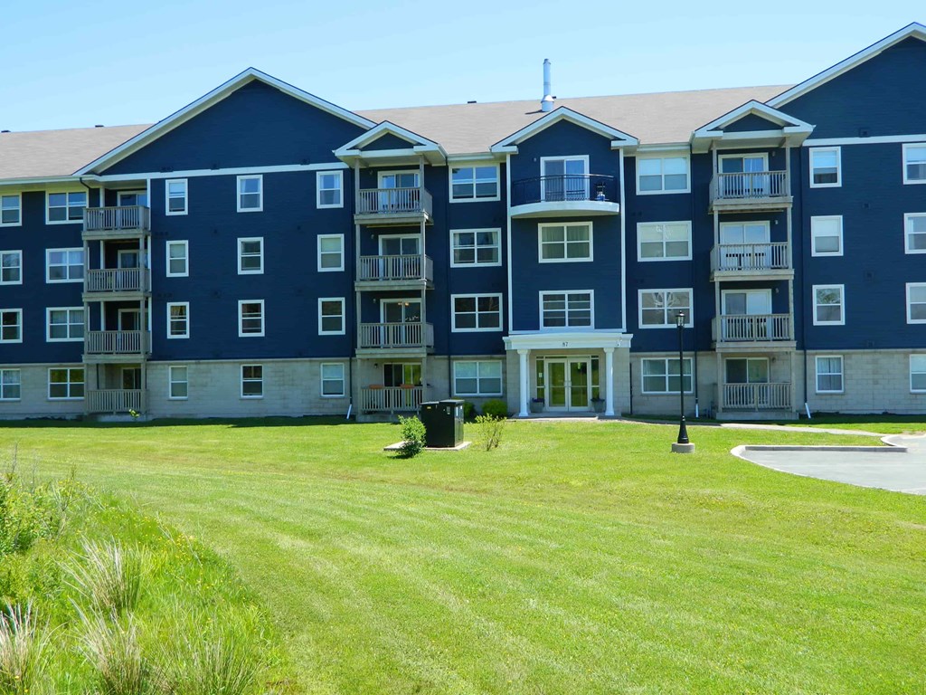 A large apartment complex with a grassy area in front.