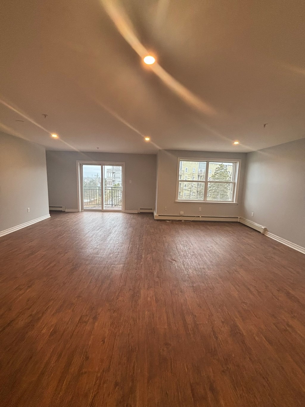 A room with wooden floors and two windows.
