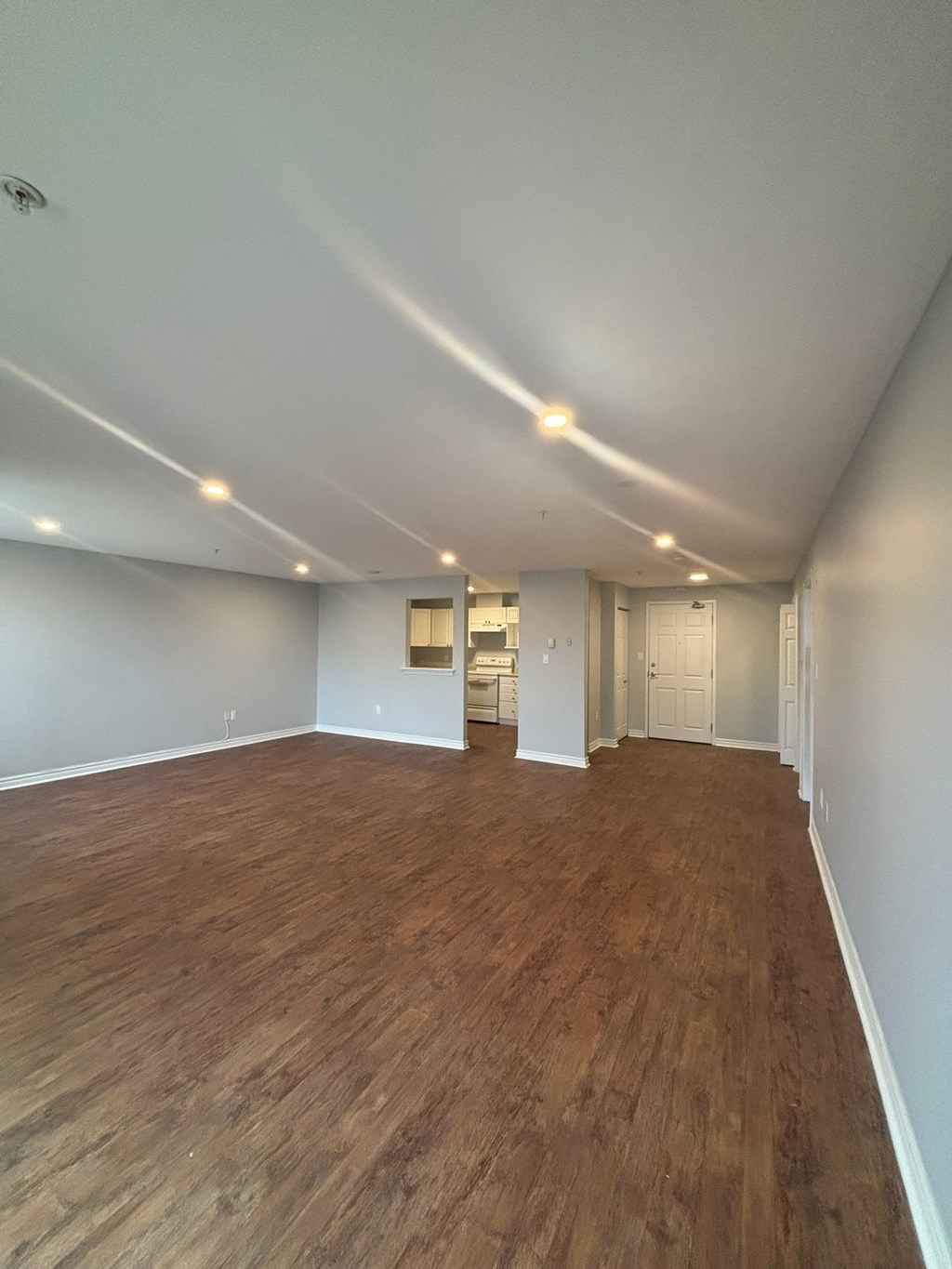 A room with wooden flooring and white walls.