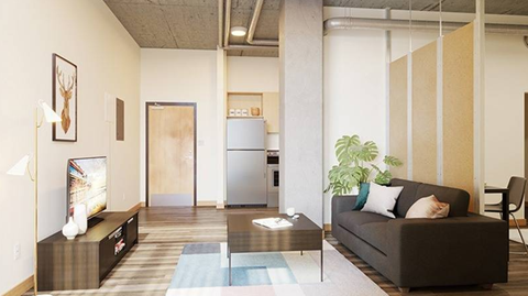 A living room with a couch, a coffee table, and a television.