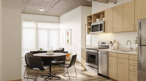 A kitchen with a table and chairs in front of a window.