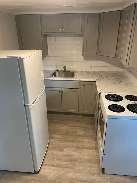 A white refrigerator is in a kitchen with a white tiled backsplash.