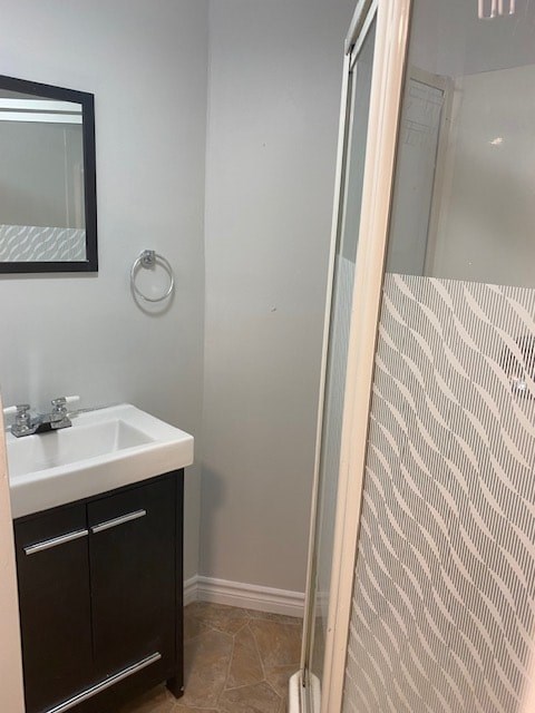 A bathroom with a sink and a shower door.
