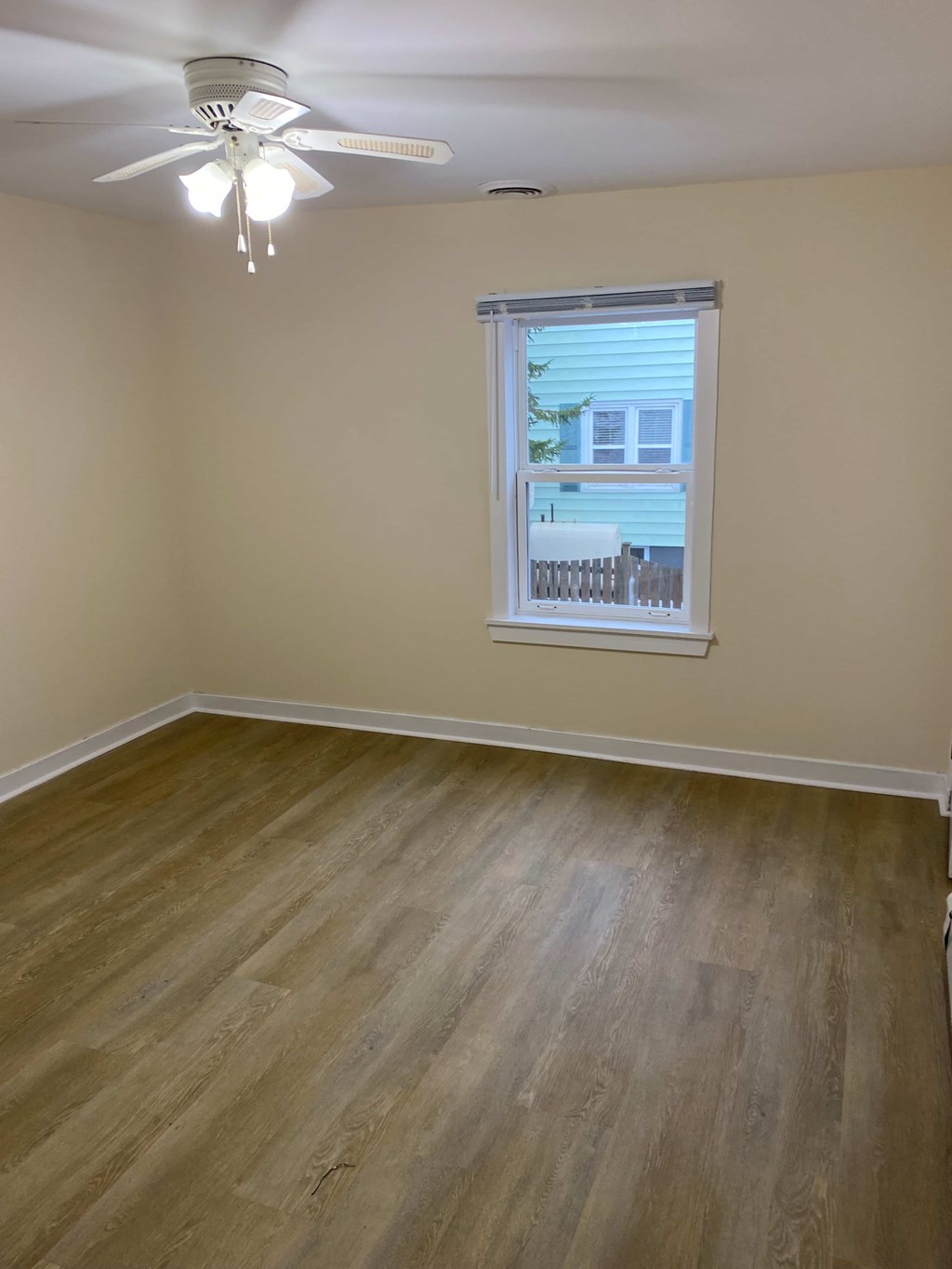 A room with a ceiling fan and a window.