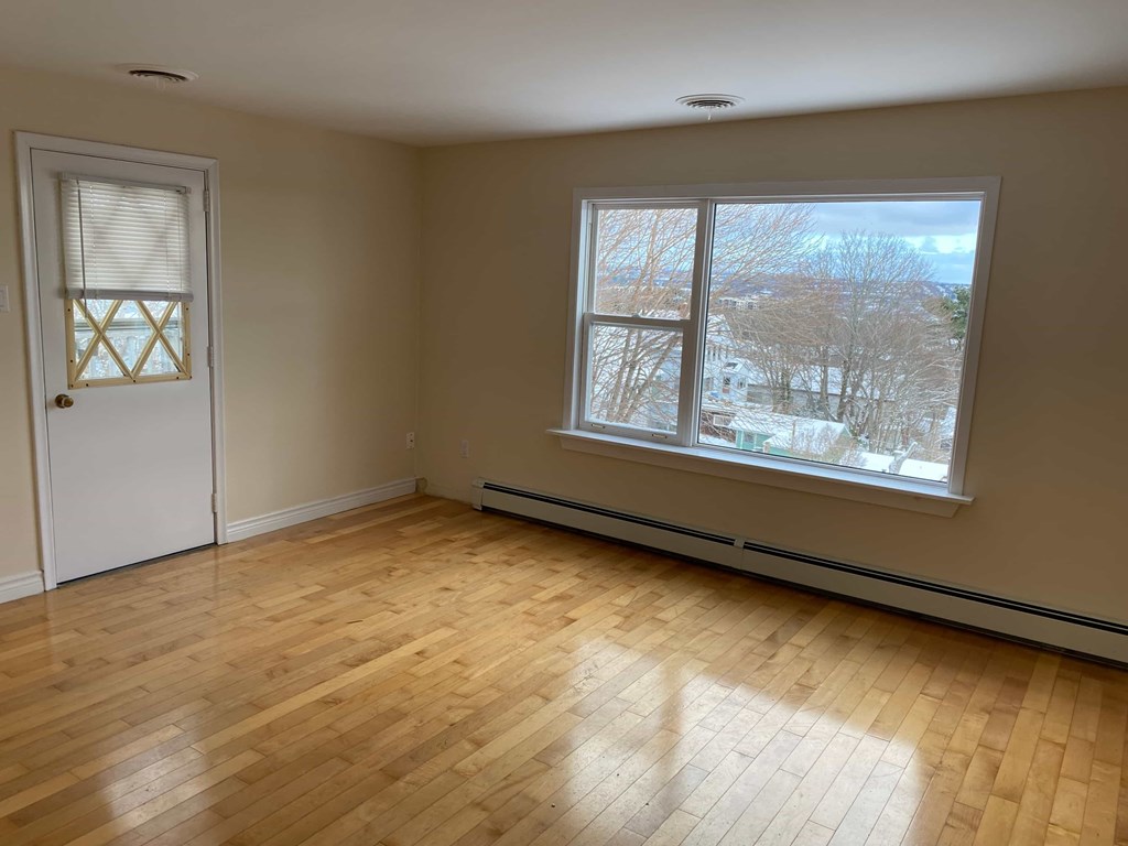 A room with a wooden floor and a window showing a snowy landscape outside.
