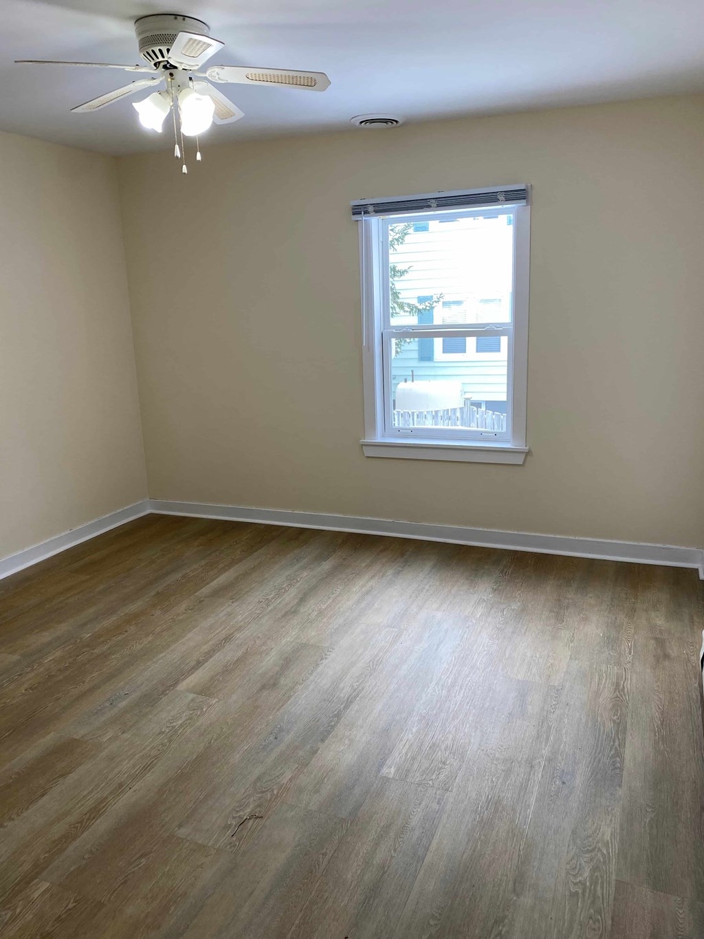 A room with a ceiling fan and a window.