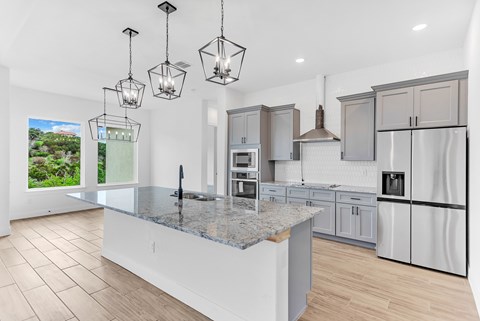 A kitchen with a granite countertop and a view of the outdoors.