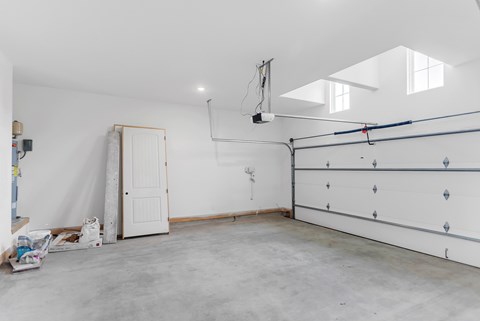 A room with a white door and a white wall with a window.