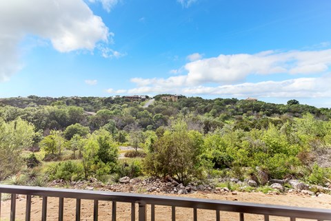 A landscape with a lot of greenery and a cloudy sky.