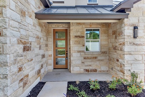 A house entrance with a brown door and a window.