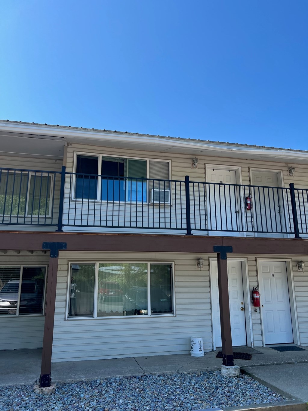 A two-story house with a balcony and a fire extinguisher on the door.