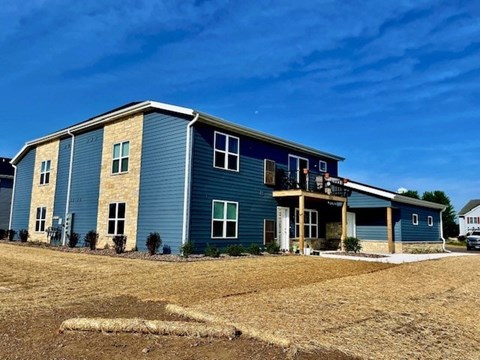 A blue house with a white door and windows.