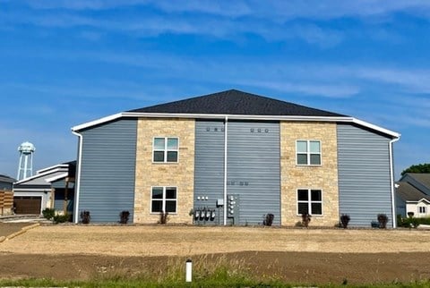 A large, modern building with a grey exterior and a black roof.