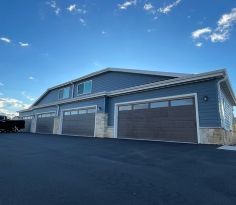 A large two-story garage with a car parked in front.