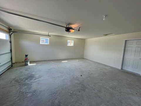 A spacious garage with a concrete floor and white walls.