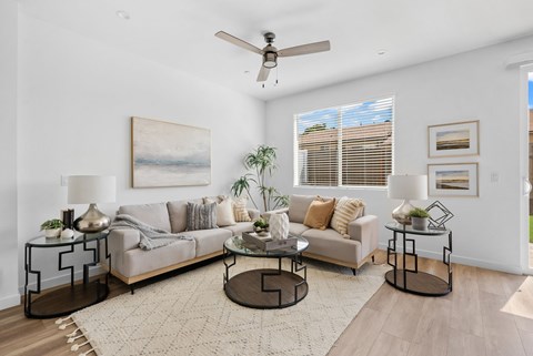 A living room with a grey couch, a coffee table, and a painting on the wall.