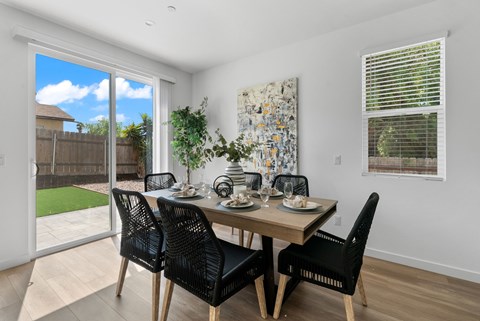 A dining room with a table set for four.