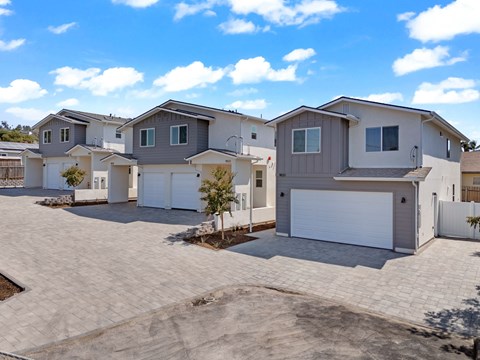 A row of houses with garages and driveways.