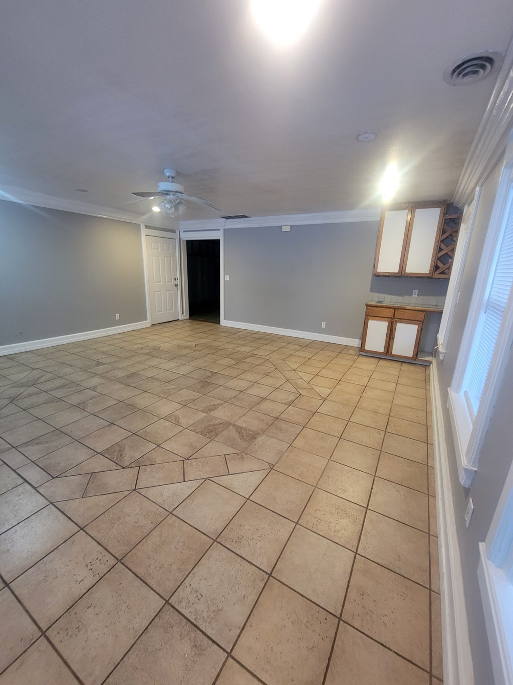 A room with a tile floor and a ceiling fan.
