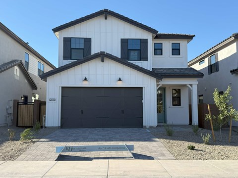 A modern house with a white exterior and a black garage door.