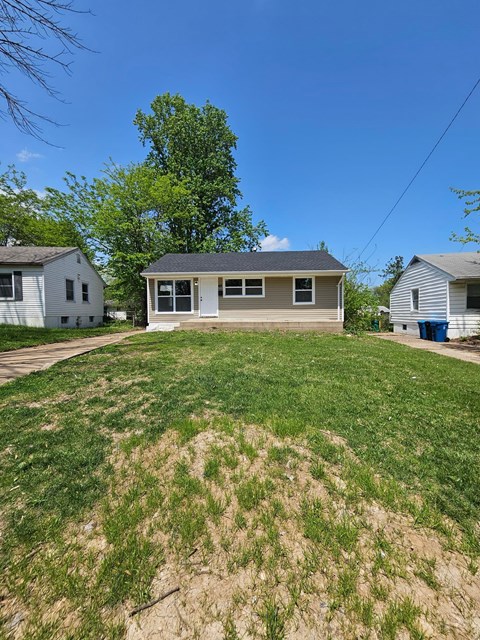 A house with a brown roof and a white garage door is in the background.