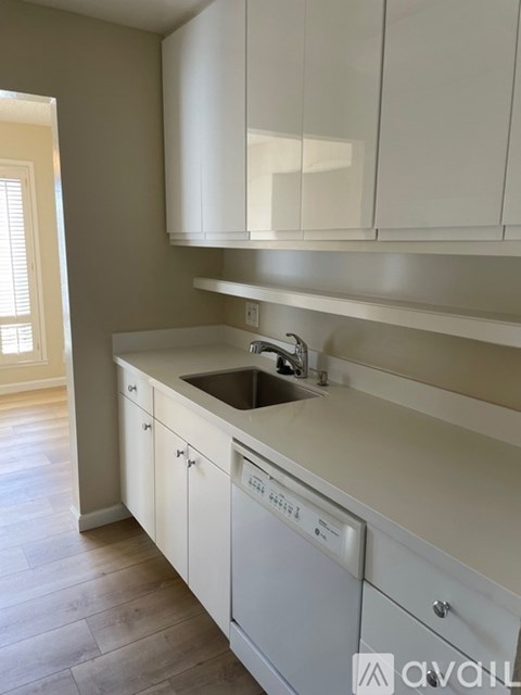 A kitchen with white cabinets and a washing machine.