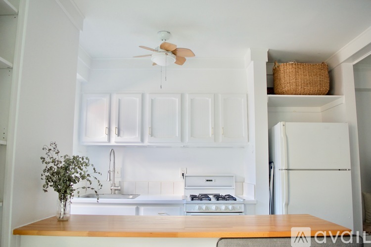 A kitchen with white cabinets and a wooden countertop.