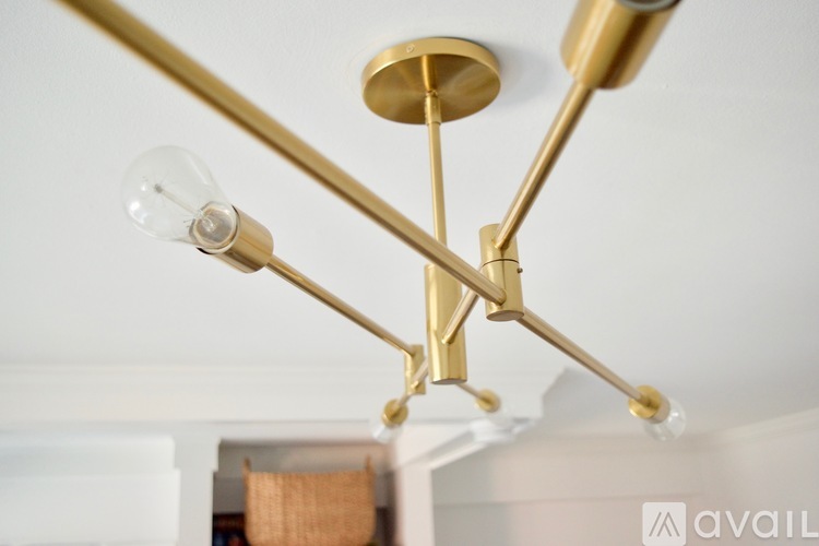 A brass chandelier with three lights hanging from the ceiling.