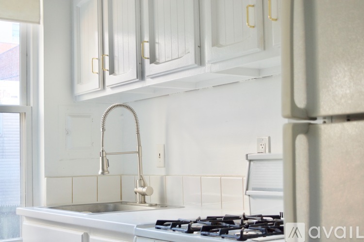 A kitchen with white cabinets and a stove top oven.