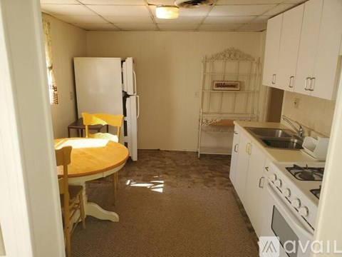 A kitchen with white cabinets and a white fridge.