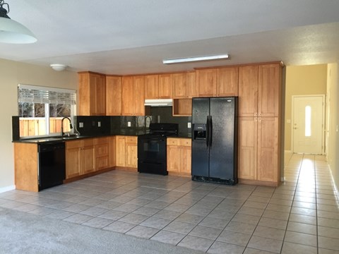 A kitchen with black appliances and wooden cabinets.