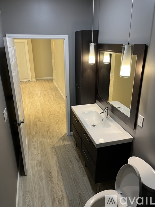 A bathroom with a sink, mirror, and toilet.