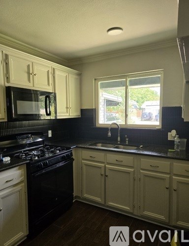 A kitchen with black countertops and white cabinets.