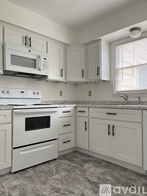 A kitchen with white appliances and cabinets.