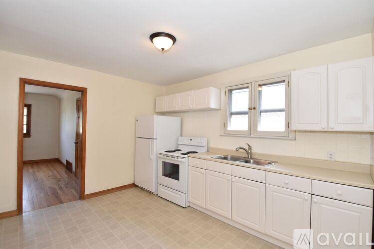 A kitchen with white cabinets and appliances.