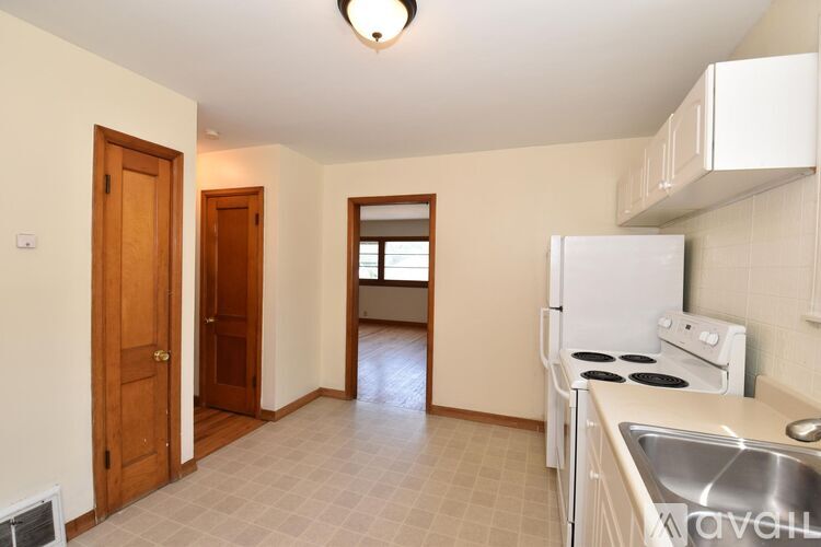 A kitchen with a white fridge, stove, and sink.