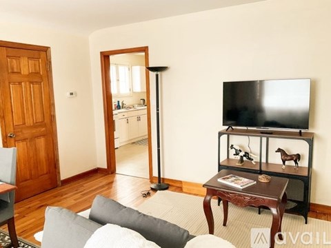 A living room with a grey couch and a black television.