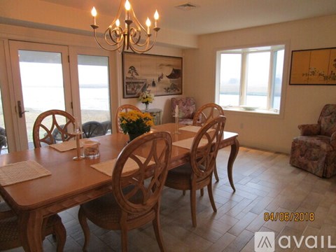 A dining room with a wooden table and chairs.