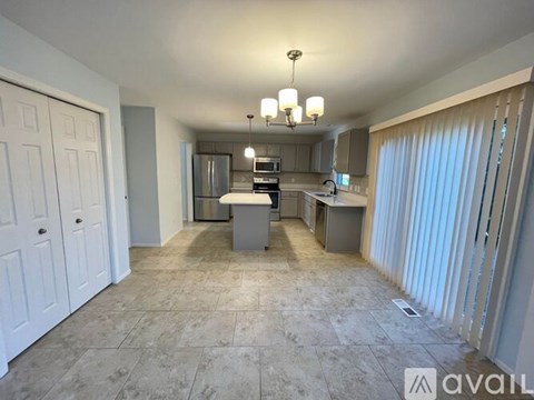 A kitchen area with a counter, cabinets, and a fridge.